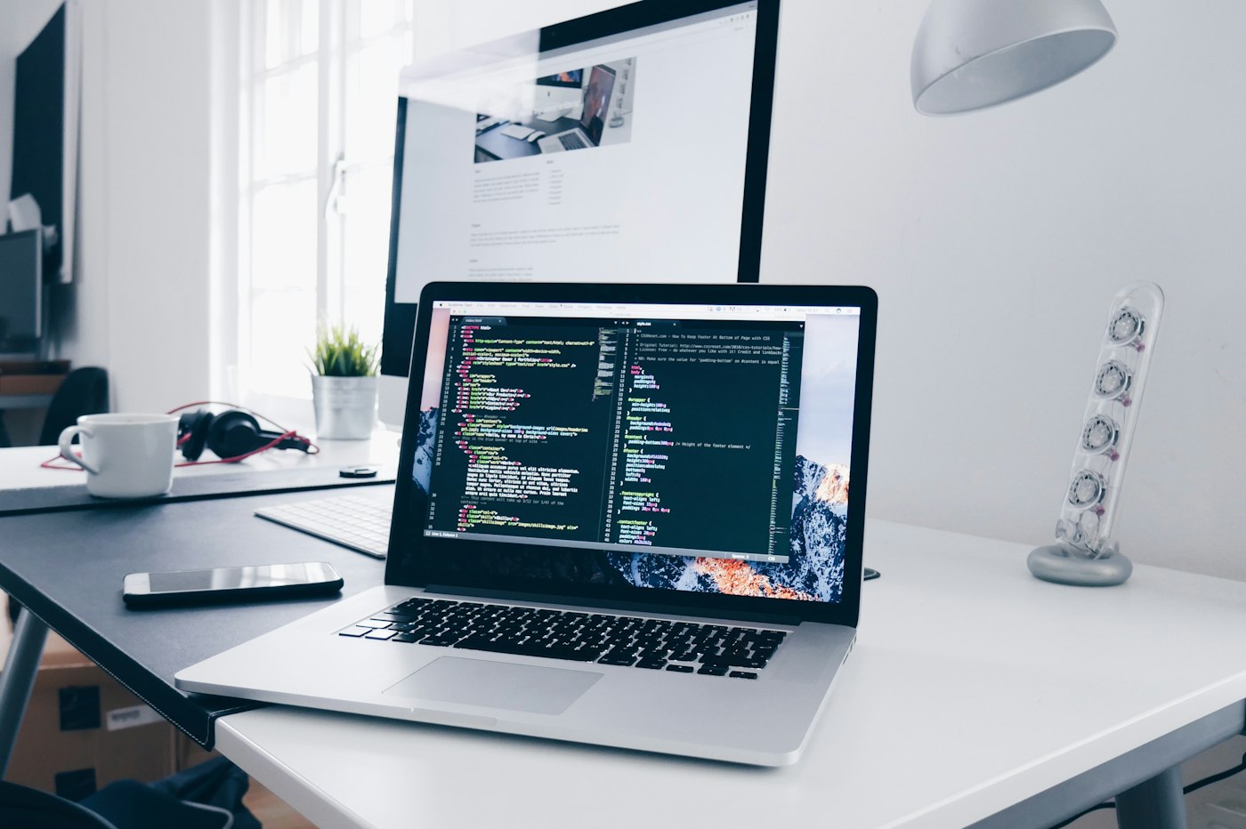 Laptop and monitor on a software development desk