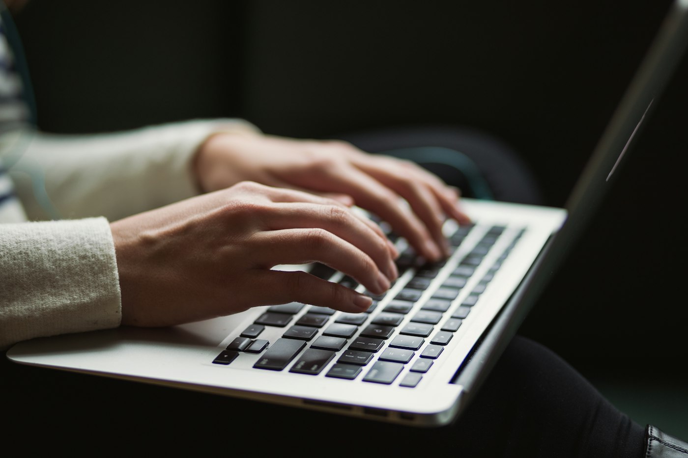 Hands typing on a laptop keyboard